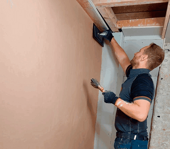 Plasterer applying a skim coat to a wall in Norfolk – expert skimming technique